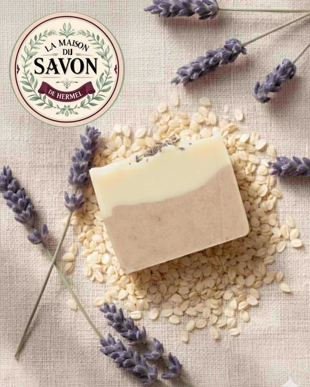 A bar of Lavender & Oat soap resting on oat flakes, surrounded by lavender sprigs